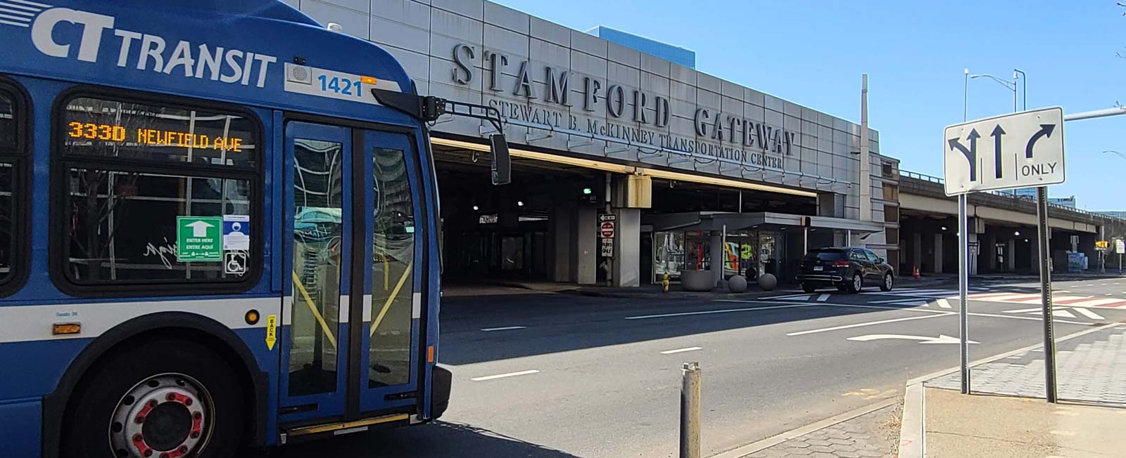 Transit bus on the roadway outside the Stamford Gateway building.