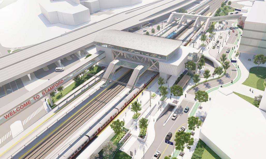 Oblique aerial view of redered STC concept, parking garage, adjacent buildings, and highway with traveling cars and trucks.