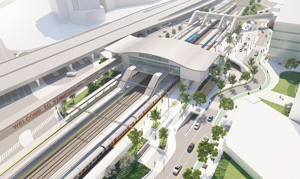 Oblique aerial view of redered STC concept, parking garage, adjacent buildings, and highway with traveling cars and trucks.